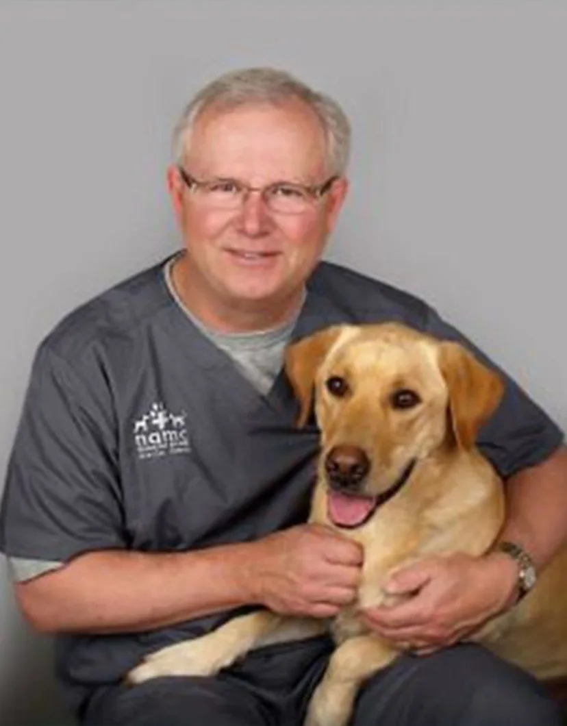 Dr. Kent Forney holding happy dog.
